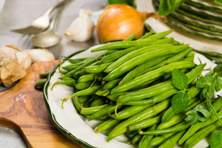 Fresh green snap beans on the plate ready to cook, healthy foodの写真素材