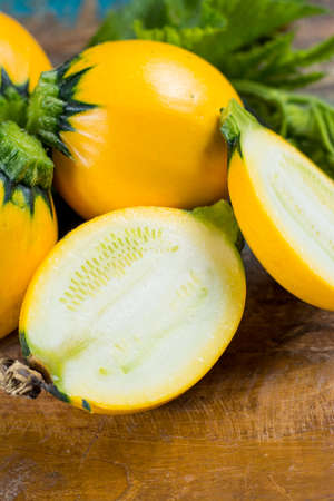 Round yellow courgette or zucchini, on wooden background, close up, healthy foodの写真素材