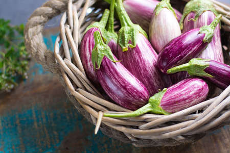 Vegetarian menu template - small fresh eggplants on wooden table copy space, healthy food