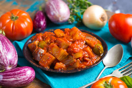 Best italian food - sicilian caponata with eggplants, tomatoes, onion, garlic and herbs, healthy vegetarian foodの写真素材