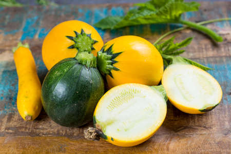 Round yellow courgette or zucchini, on wooden background, close up, healthy foodの写真素材