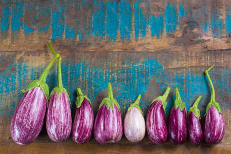Vegetarian menu template - small fresh eggplants on wooden table copy space, healthy foodの写真素材