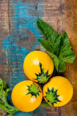 Round yellow courgette or zucchini, on wooden background, copy space, healthy foodの写真素材
