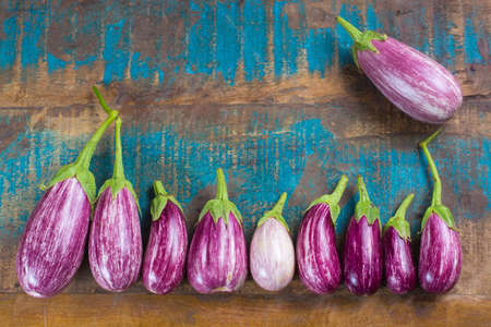Vegetarian food - small fresh eggplants on wooden table copy space, healthy foodの写真素材