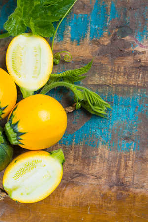 Round yellow courgette or zucchini, on wooden background, close up, healthy foodの写真素材