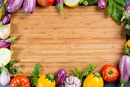 Bamboe plate with copy space, restautant concept with fresh colorful organic vegetables - round courgette, small eggplants, tomatoes, diet concept, Italian and French food, healthy food. Menu temptale.の写真素材