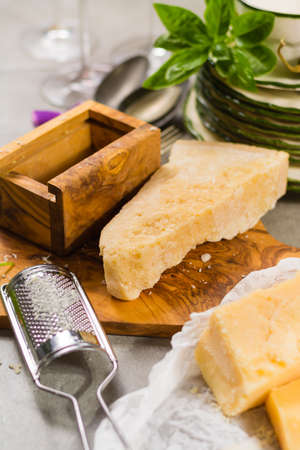 Aged parmesan cheese on the olive wooden board, italian foodの写真素材