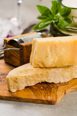 Aged parmesan cheese on the olive wooden board, italian foodの写真素材