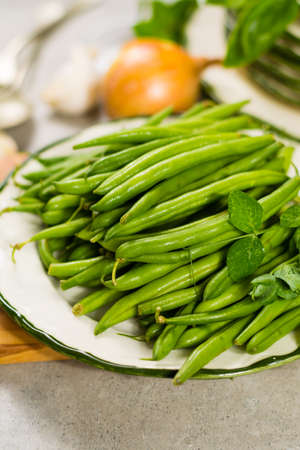 Fresh green snap beans on the plate ready to cook, healthy foodの写真素材