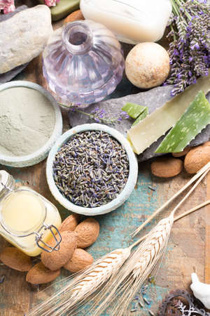 Nature cosmetics, handmade preparation with essential oils and ancient minerals of  parfums, skincare, creams, soaps from fresh and dried lavender flowers, roses, wheat, almond nuts, green clay powder in French artisanal boutique home style, top viewの写真素材