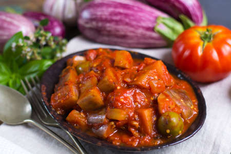 Best italian food - sicilian caponata with eggplants, tomatoes, onion, garlic and herbs, healthy vegetarian foodの写真素材