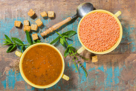 Homemade red lentils soup in yellow bowl with mintの写真素材