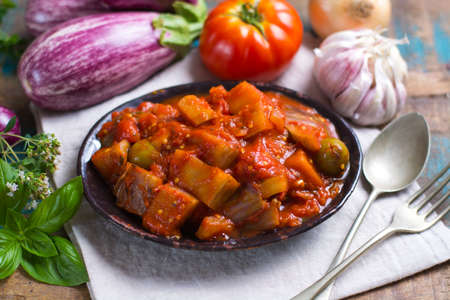 Best italian food - sicilian caponata with eggplants, tomatoes, onion, garlic and herbs, healthy vegetarian foodの写真素材