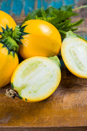 Round yellow courgette or zucchini, on wooden background, close up, healthy foodの写真素材