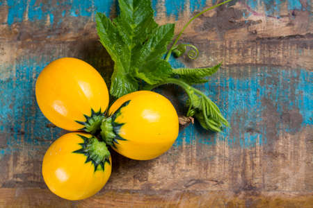 Round yellow courgette or zucchini, on wooden background, copy space, healthy foodの写真素材