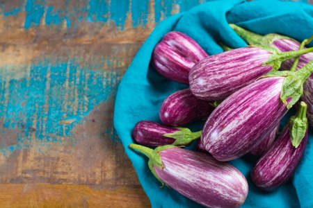 Vegetarian menu template - small fresh eggplants on wooden table copy space, healthy foodの写真素材