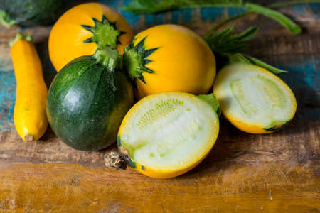 Round yellow courgette or zucchini, on wooden background, close up, healthy foodの写真素材