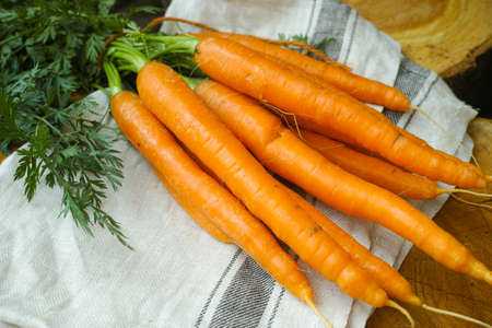 Bunch of fresh summer carrots on wooden tableの写真素材