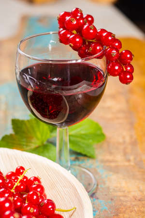 Fresh ripe red currant berries and liqueur on the table, healthy foodの写真素材