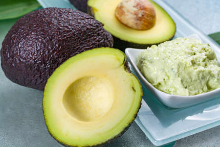 Avocado skin & hair care home spa, ripe avocados and bowl with homemade fresh avocado mask, nature laboratoryの写真素材
