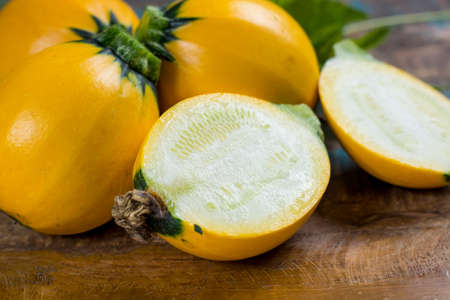 Round yellow courgette or zucchini, on wooden background, close up, healthy foodの写真素材