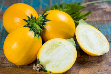 Round yellow courgette or zucchini, on wooden background, close up, healthy foodの写真素材