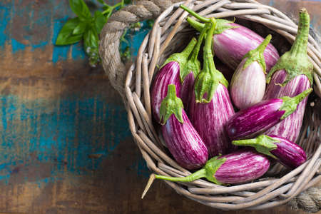 Vegetarian menu template - small fresh eggplants on wooden table copy space, healthy foodの写真素材