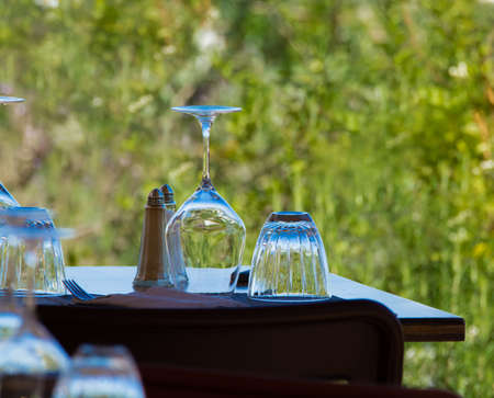 Empty wine glasses on the table served for lunch, dinner in cafe, restaurant outside or on terrase, vacation timeの写真素材