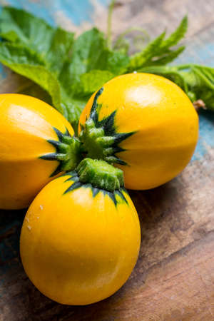 Round yellow courgette or zucchini, on wooden background, close up, healthy foodの写真素材