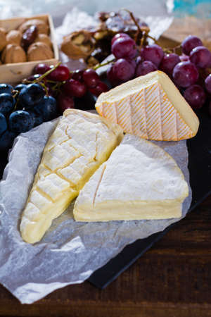 Famous French soft cheese - brie - delicious dessert with nuts, grapes and dried fruitsの写真素材