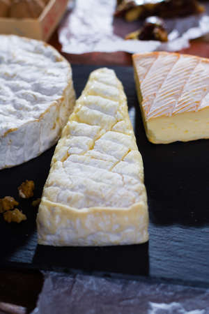 Variety of French soft cheeses - camembert, marcaire, munster, brie - delicious dessert with nuts and dried fruitsの写真素材