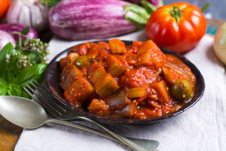 Best italian food - sicilian caponata with eggplants, tomatoes, onion, garlic and herbs, healthy vegetarian foodの写真素材