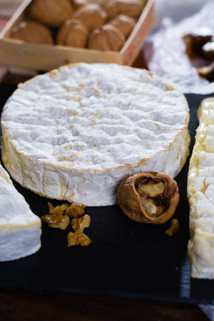 Variety of French soft cheeses - camembert, marcaire, munster, brie - delicious dessert with nuts and dried fruitsの写真素材