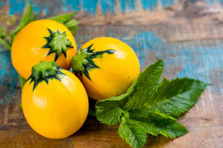 Round yellow courgette or zucchini, on wooden background, copy space, healthy foodの写真素材