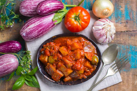 Best italian food - sicilian caponata with eggplants, tomatoes, onion, garlic and herbs, healthy vegetarian foodの写真素材