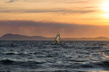 Sunset over the sea or ocean and extreme freestyle sport windsurfing, France, Giensの写真素材