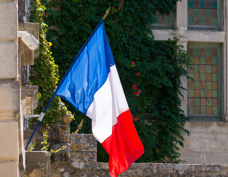 Flag of France (French: Drapeau franÃ§ais) is a tricolour flag featuring three vertical bands coloured blue (hoist side), white, and red. Oudoors, blue sky, copy space.のeditorial素材