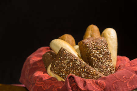 Variety of fresh baked wheat and rye bread, baguette and buns with wheat ears