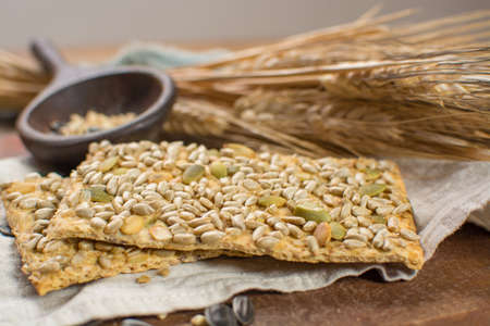 Whole grain wheat flour, sunflowers seeds and healthy fresh baked crackers close upの写真素材
