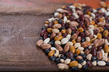 Variety of protein rich colorful raw dried beans on wooden tableの写真素材