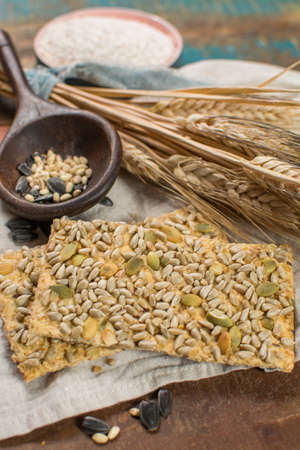 Whole grain wheat flour, sunflowers seeds and healthy fresh baked crackers close upの写真素材