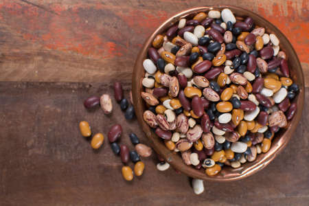 Variety of protein rich colorful raw dried beans on wooden tableの写真素材
