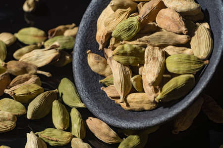 Macro collection, dried green cardamom pods close up on black backgroundの写真素材