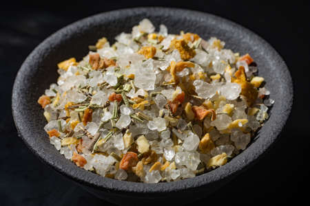 Macro collection, white sea salt mixed with italian herbs, rosemary and spices on black background