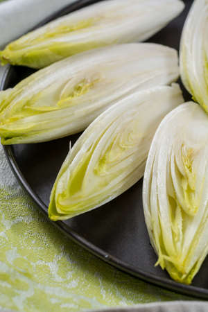 Fresh raw Belgian bitter chicory salad ready to cook, close upの写真素材