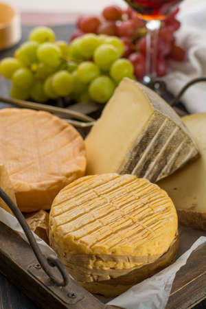 Tasting of oldest french AOC soft pudgent yellow cheese Livarot, Munster and semifirm Tomme, made...