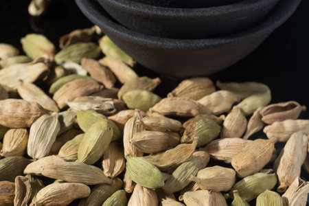 Macro collection, dried green cardamom pods close up on black backgroundの写真素材