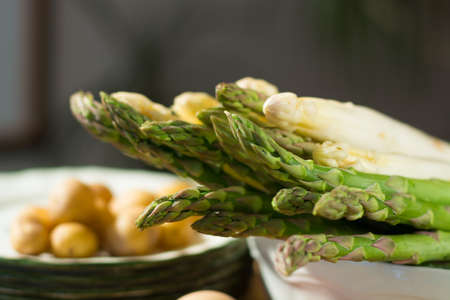 Raw uncooked white and green asparagus with eggs and potatoes, ready to cook for dinnerの写真素材