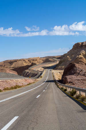 Asphalt road in desert Negev, Israel, road 12, transport infrastructure in desert, view on fence...
