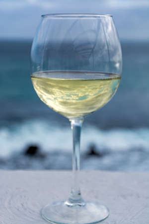 One glass of cold white wine served on outdoor terrace with beautiful romantic  sea view